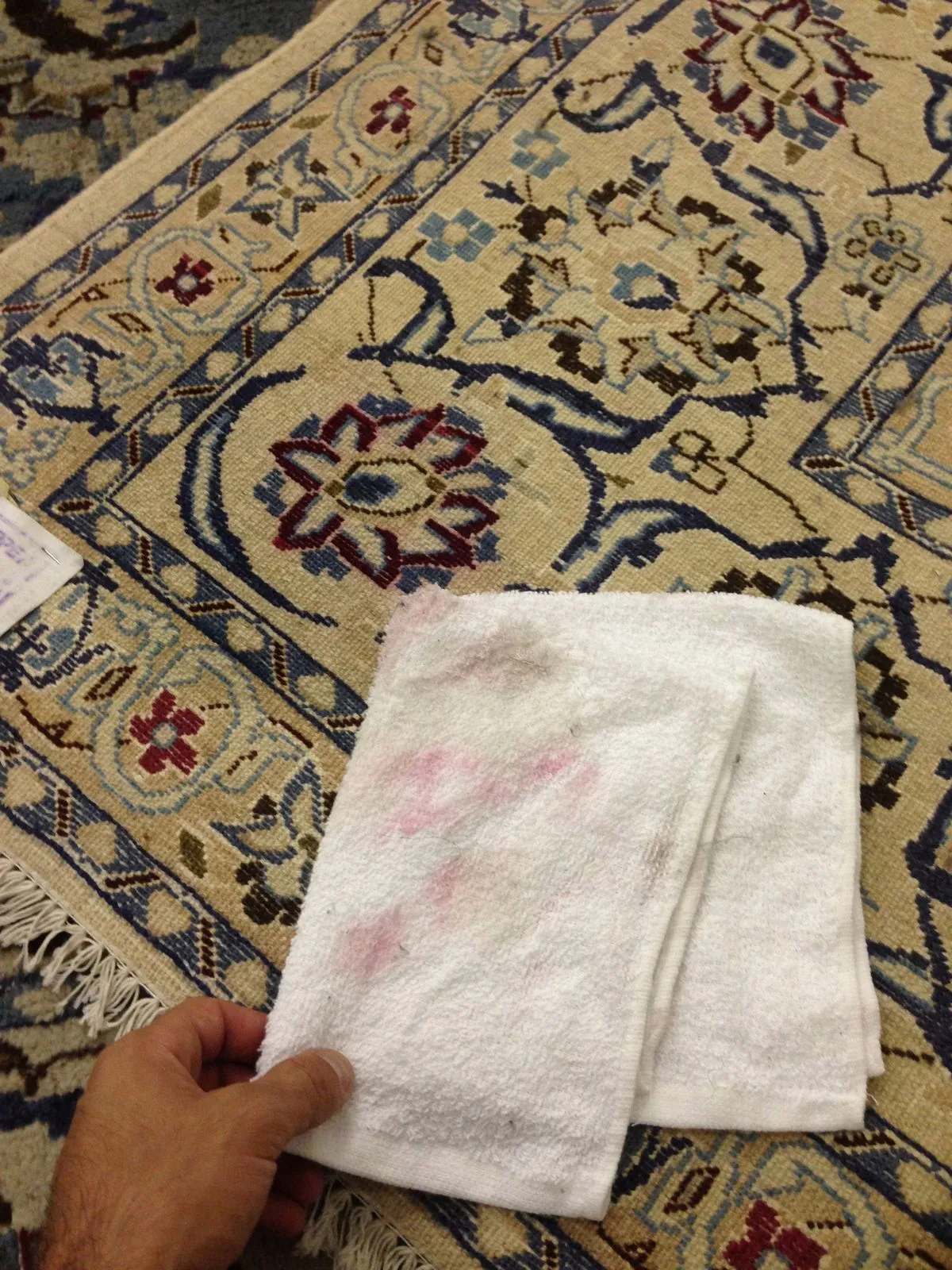 White towel showing pink dye transfer during a color-bleed check