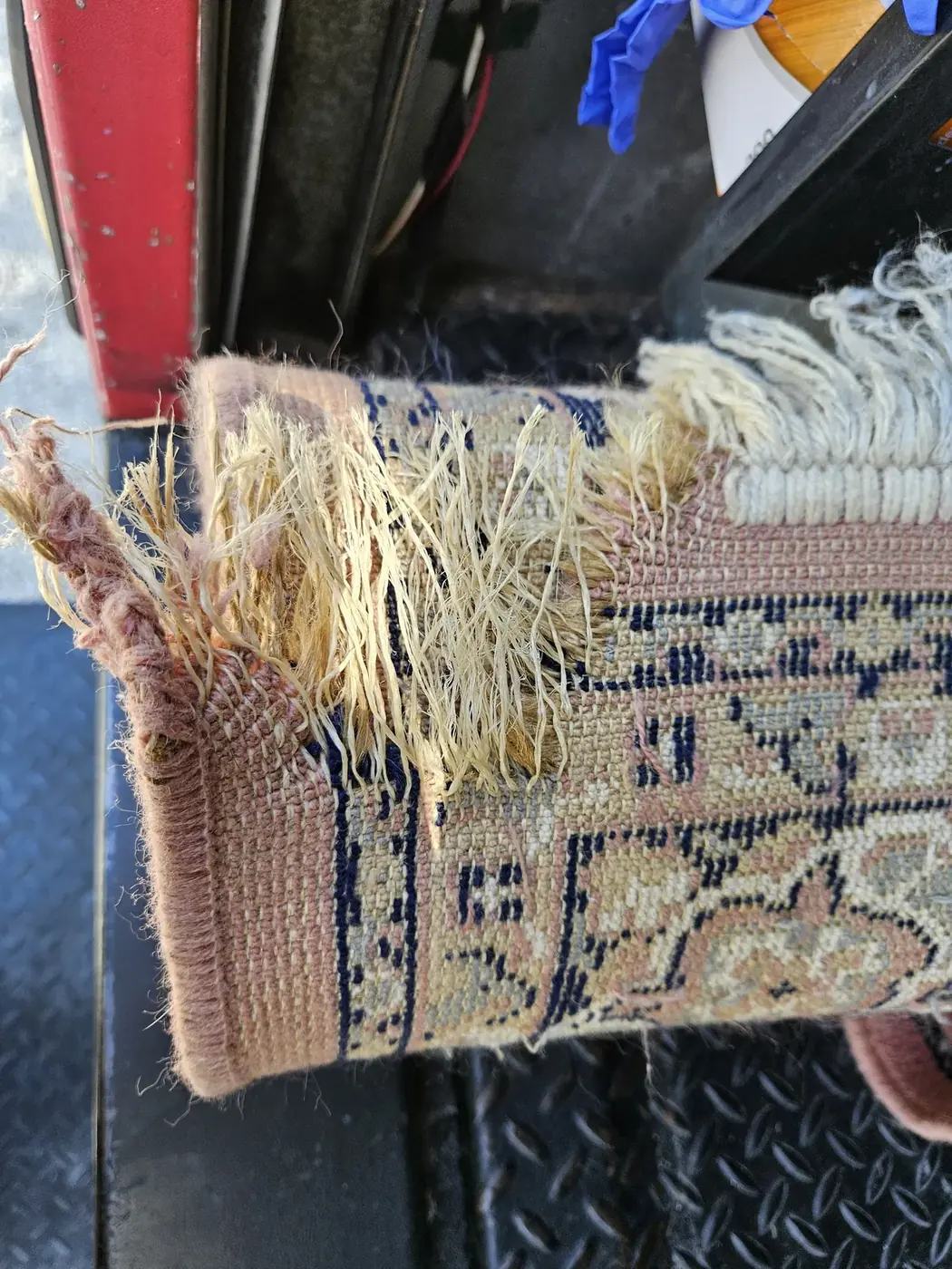 Worn fringe on the corner of an Oriental rug